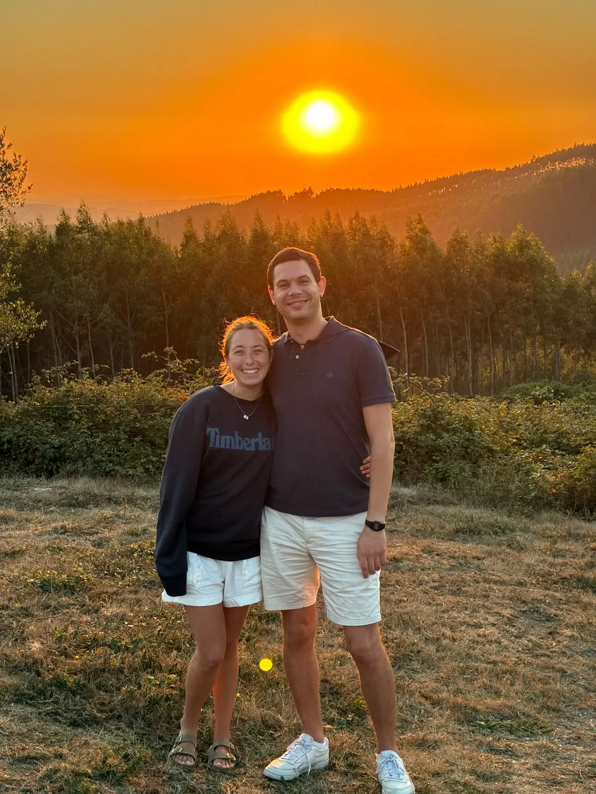 Cata y Sebas abrazados frente a un atardecer