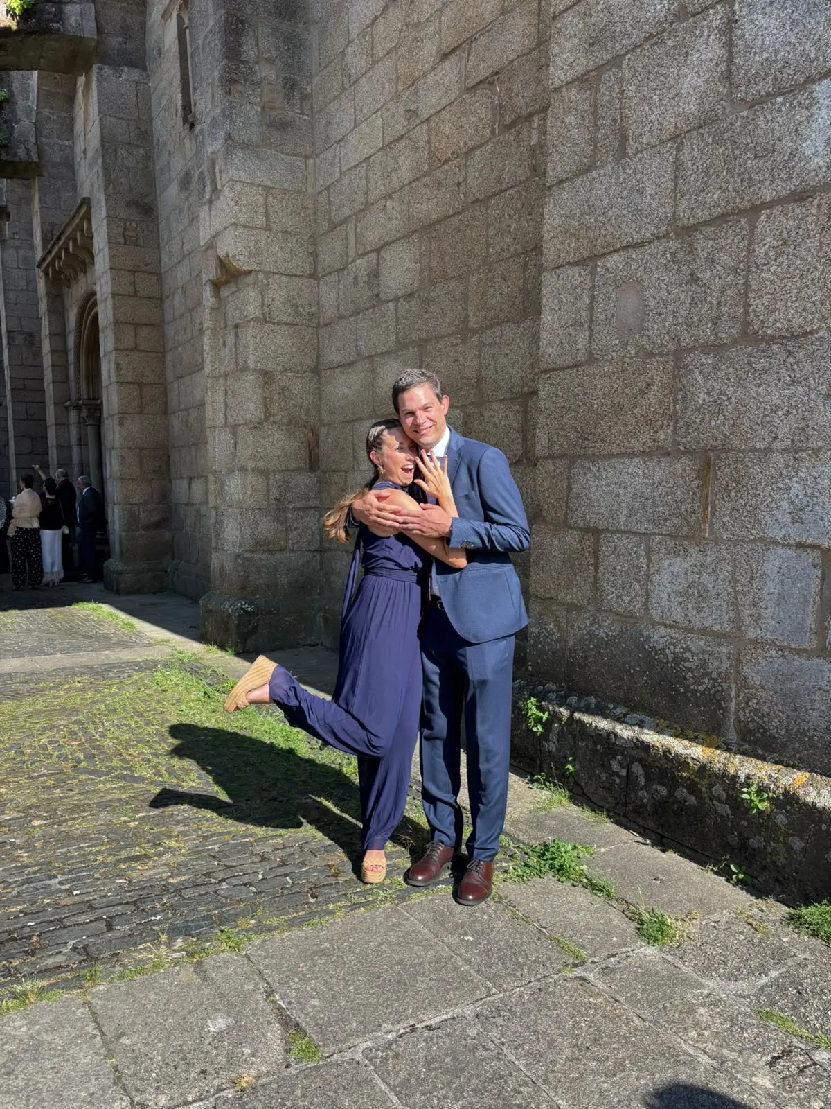 Cata y Sebas riéndose frente a una iglesia de piedra